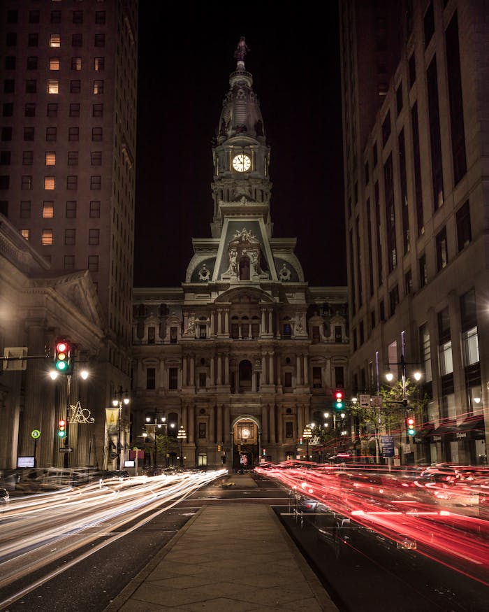 Long exposure of Philadelphia City Hall at night with colorful light trails.